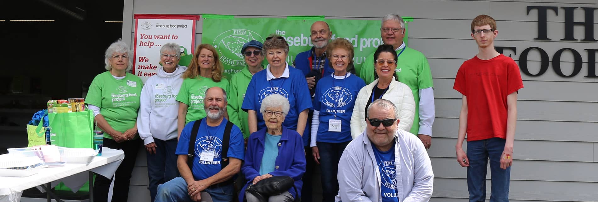 a group of FISH Food Pantry volunteers poses outside of the building with the executive director
