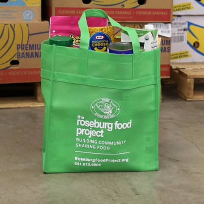 a green Food Project bag with various food items