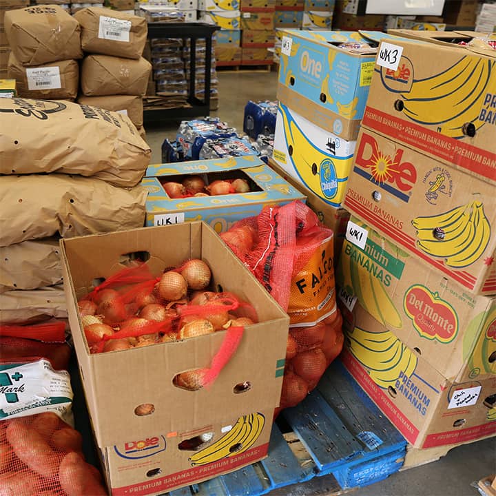 boxes and bags of fresh produce such as onions, potatoes, and fruit